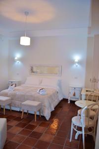 a bedroom with a bed and two chairs and a table at La Magnolia 140 in Fiumicino