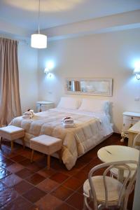 a bedroom with a large bed with two chairs and a table at La Magnolia 140 in Fiumicino
