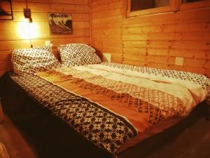 - un grand lit dans une chambre dotée de murs en bois dans l'établissement Chalet California Dreamin Route 66, à Casteil