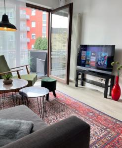 a living room with a couch and a flat screen tv at Living at Saarpartments with 2 Bedrooms, Netflix - Business & Holiday Apartments for Long- and Short term Stay, 3 min to Train Station and Europa Galerie in Saarbrücken