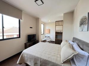 een slaapkamer met een groot bed en een tafel bij HERMOSO MONOAMBIENTE LOS ROBLES in Cochabamba