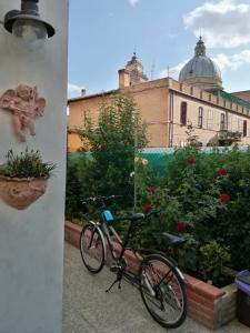 una bicicleta estacionada en un jardín con un edificio al fondo en La Corte degli Angeli Locazioni Turistiche, en Asís