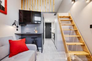 ウッチにあるU Fabrykanta by LookApの階段とリビングルームが備わる小さなアパートメントです。