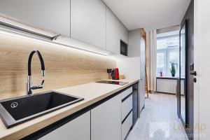 a kitchen with white cabinets and a sink at U Fabrykanta by LookAp in Łódź