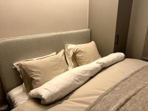 a bed with white pillows on top of it at Elegant lägenhet i Professorstaden in Lund