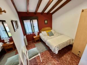 a bedroom with a bed and a chair in it at La Cabaña de Agustin in Ortiguero