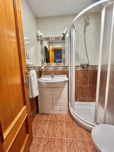 a bathroom with a shower and a sink and a tub at La Cabaña de Agustin in Ortiguero