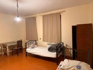 a bedroom with two beds and a table and a window at Sovet Hostel in Baku