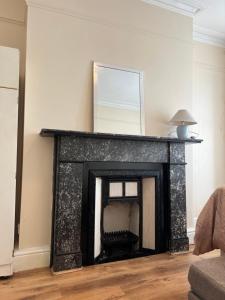 a fireplace with a mirror on top of it at Mortiara in Darlington