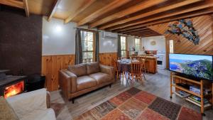 a living room with a couch and a television at Crayfish Creek Van & Cabin Park in Crayfish Creek