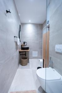 Boho Central Apartment في تيرانا: حمام ابيض مع مرحاض ومغسلة