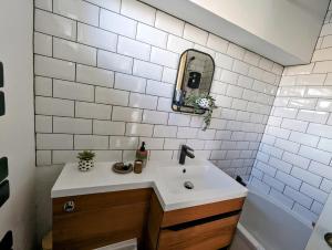 a bathroom with a sink and a mirror at New, unique, tiny house with garden in Wigston Magna