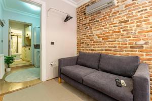 a living room with a couch against a brick wall at GALATA FİVE APARTMENTS in Istanbul