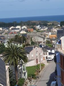 Vistas al mar de una pequeña ciudad con una palmera en Apartamento Exclusivo Centrico con parking, en Ribadeo