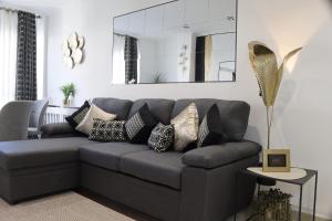 un sofá gris con almohadas en la sala de estar en Apartamento Exclusivo Centrico con parking, en Ribadeo