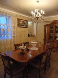a dining room table with chairs and a chandelier at Family house in Sevan