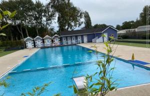 a large blue swimming pool with a row of huts at Swift Retreat - Haven Wild Duck Holiday Park in Belton