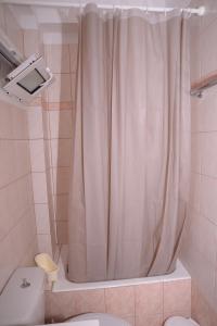 y baño con cortina de ducha y aseo. en Blue Lagoon en Loutraki