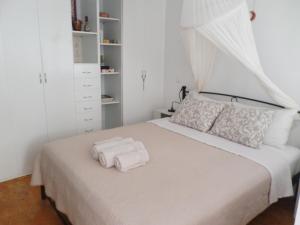 a bedroom with a bed with two towels on it at In the heart of Hydra in Hydra