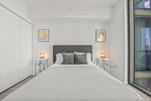 1 dormitorio blanco con 1 cama grande y 2 mesitas de noche en TR Miami 2 Bedroom Condo and Studio with Balcony, en Miami