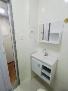 La salle de bains blanche est pourvue d'un lavabo et d'un miroir. dans l'établissement Studio Prime - Niterói 704, à Niterói