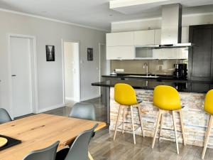 kuchnia z żółtymi krzesłami i drewnianym stołem w obiekcie Happy Moor w mieście Rellingen