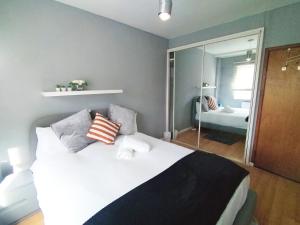 a bedroom with a bed with pillows and a mirror at Central London rooms EC1V in London