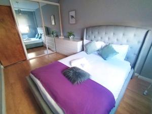 a bedroom with a large bed with a purple blanket at Central London rooms EC1V in London