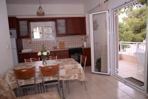 a kitchen with a table and chairs and a balcony at Blue Lagoon in Loutraki
