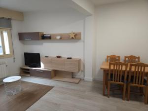 a living room with a tv and a table with chairs at Apartamento Redondela céntrico in Pontevedra
