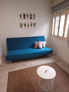 Sofá azul en la sala de estar con mesa en Apartamento Redondela céntrico, en Pontevedra