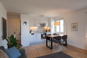 cocina y sala de estar con mesa y sillas en Jungstay Apartments- near Basel en Basilea