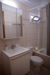 La salle de bains est pourvue de toilettes, d'un lavabo et d'un miroir. dans l'établissement Blue Lagoon, à Loutraki