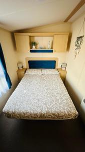 a small bedroom with a bed in a room at Cozy Private Static Caravan at Llyons Robin Hood - Silver Birch Way 11 in Rhyl