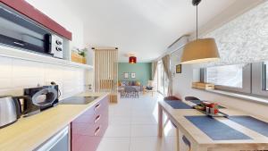 a kitchen with a counter top and a living room at Na Domečku Valtice in Valtice