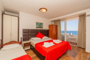 a bedroom with two beds and a view of the ocean at David apartments and rooms in Dobra Voda