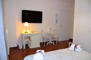 a room with a bed and a table and a television on the wall at La Magnolia 140 in Fiumicino