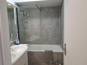 a bathroom with a tub and a sink and a shower at Appartement résidence Les Dryades in Gérardmer