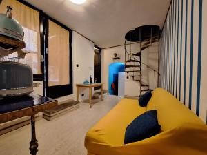 a living room with a yellow couch and a shelf at Ωlimpiα Apartment in Rome