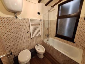 a bathroom with a toilet and a sink and a tub at Ωlimpiα Apartment in Rome