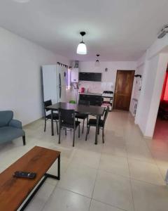 a living room with a table and chairs and a kitchen at Patagonia Sur alquiler por día in Río Gallegos