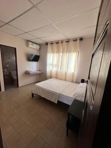 um pequeno quarto com uma cama e uma janela em Hotel Almirante Padilla em Ríohacha