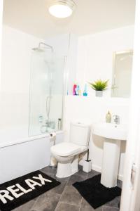 a bathroom with a toilet and a sink at Spacious 2 bedroom Flat opposite COOP Live n Etihad Stadium in Manchester