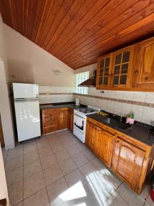 una cucina con frigorifero bianco e armadietti in legno di Casa Tilo a El Bolsón