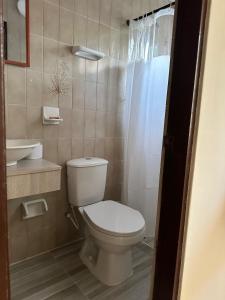 a bathroom with a toilet and a sink at Hotel Almirante Padilla in Ríohacha