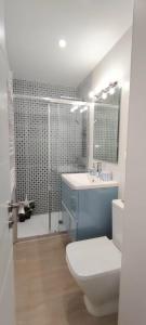 a bathroom with a toilet and a sink and a shower at Parque Playa II in Gijón