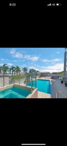 a picture of a swimming pool with palm trees at 5 minute walk to the Stadium!! Taylord Holiday Homes and Apartments in Townsville
