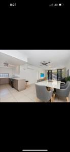 a kitchen and a living room with a table and chairs at 5 minute walk to the Stadium!! Taylord Holiday Homes and Apartments in Townsville