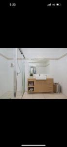 a bathroom with a shower and a sink in a room at 5 minute walk to the Stadium!! Taylord Holiday Homes and Apartments in Townsville