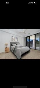 a bedroom with a large bed and a large window at 5 minute walk to the Stadium!! Taylord Holiday Homes and Apartments in Townsville